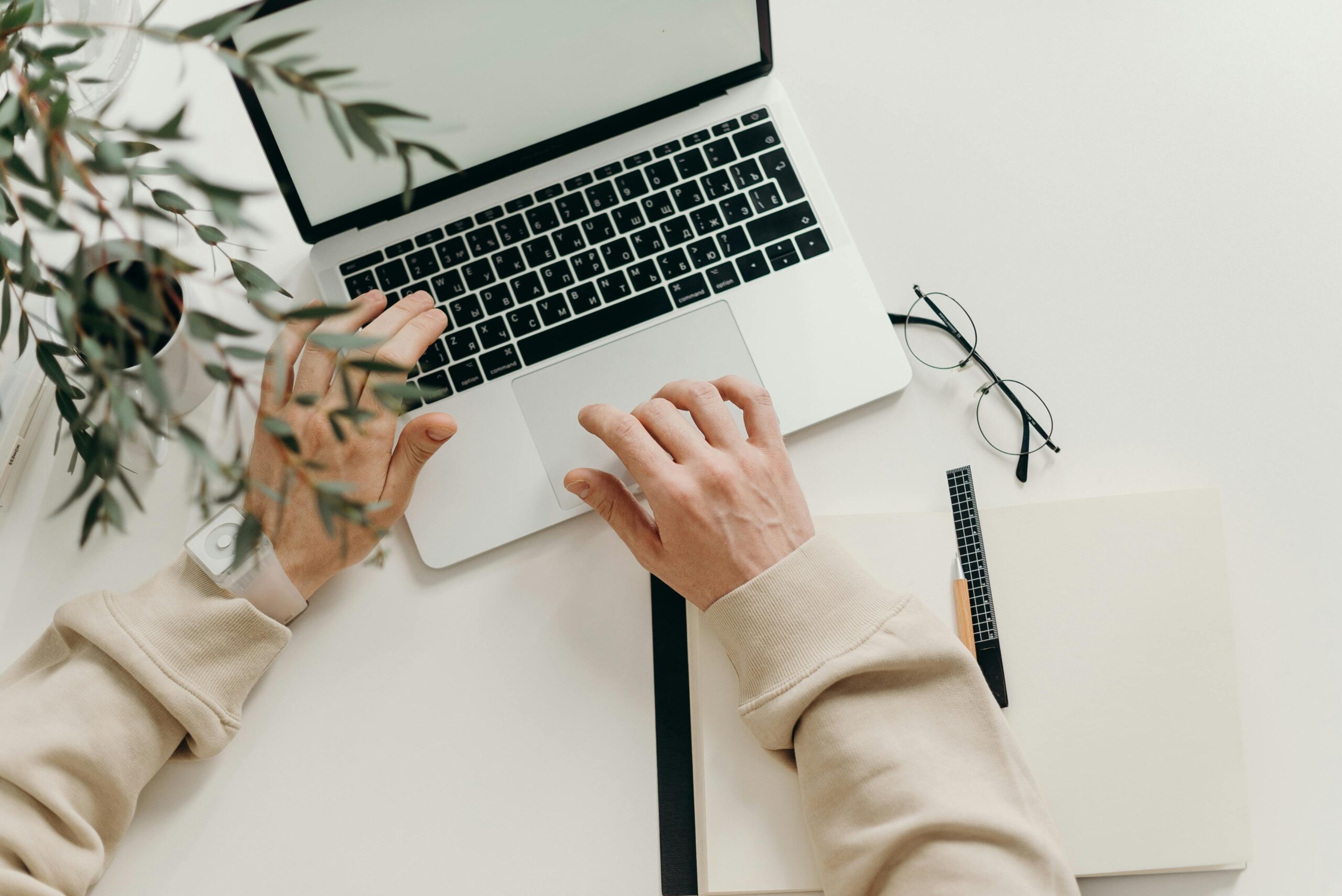 Free An overhead view of a person working on a laptop in a minimalist home office setting. Stock Photo https://www.pexels.com/photo/person-in-beige-long-sleeve-shirt-using-macbook-pro-4065876/