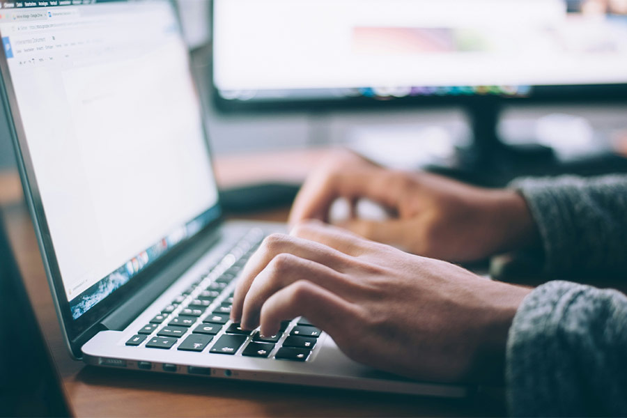 a person typing on a computer logging a support ticket. Photo by Glenn Carstens-Peters on Unsplash